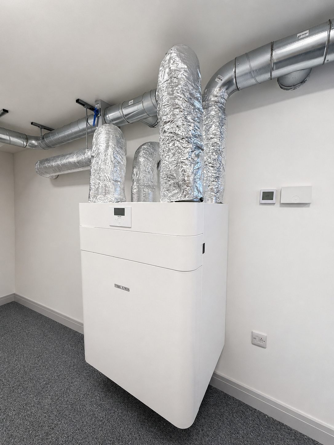 Stiebel Eltron MVHR unit installed on a wall with insulated ducting